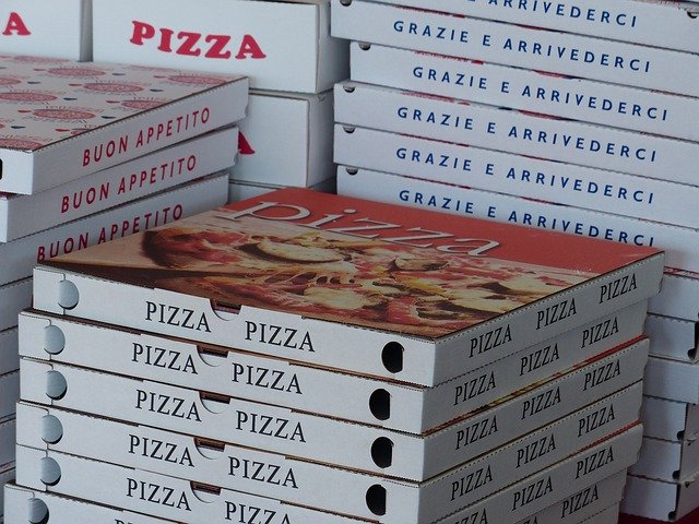 +-DIN-Format? wieviel Porto kosten wohl diese Pizzakatons. Das Foto zeigt eine Ausschnitt. Ein Stapel Kartons vorne zwei im Hintergrund.