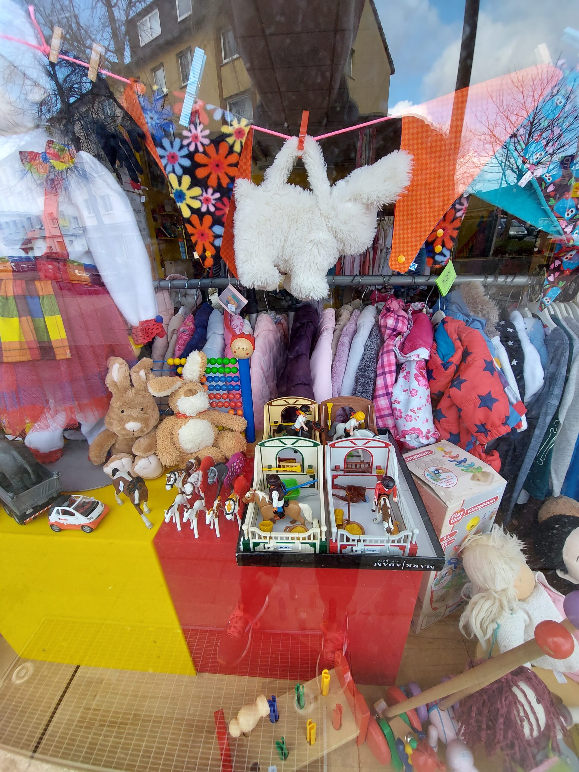 Handyfoto, Hochformat, Blick in das Schaufenster eines Spielzeugladens, weiße Plüschtasche in Hasenform mit 2 Griffen